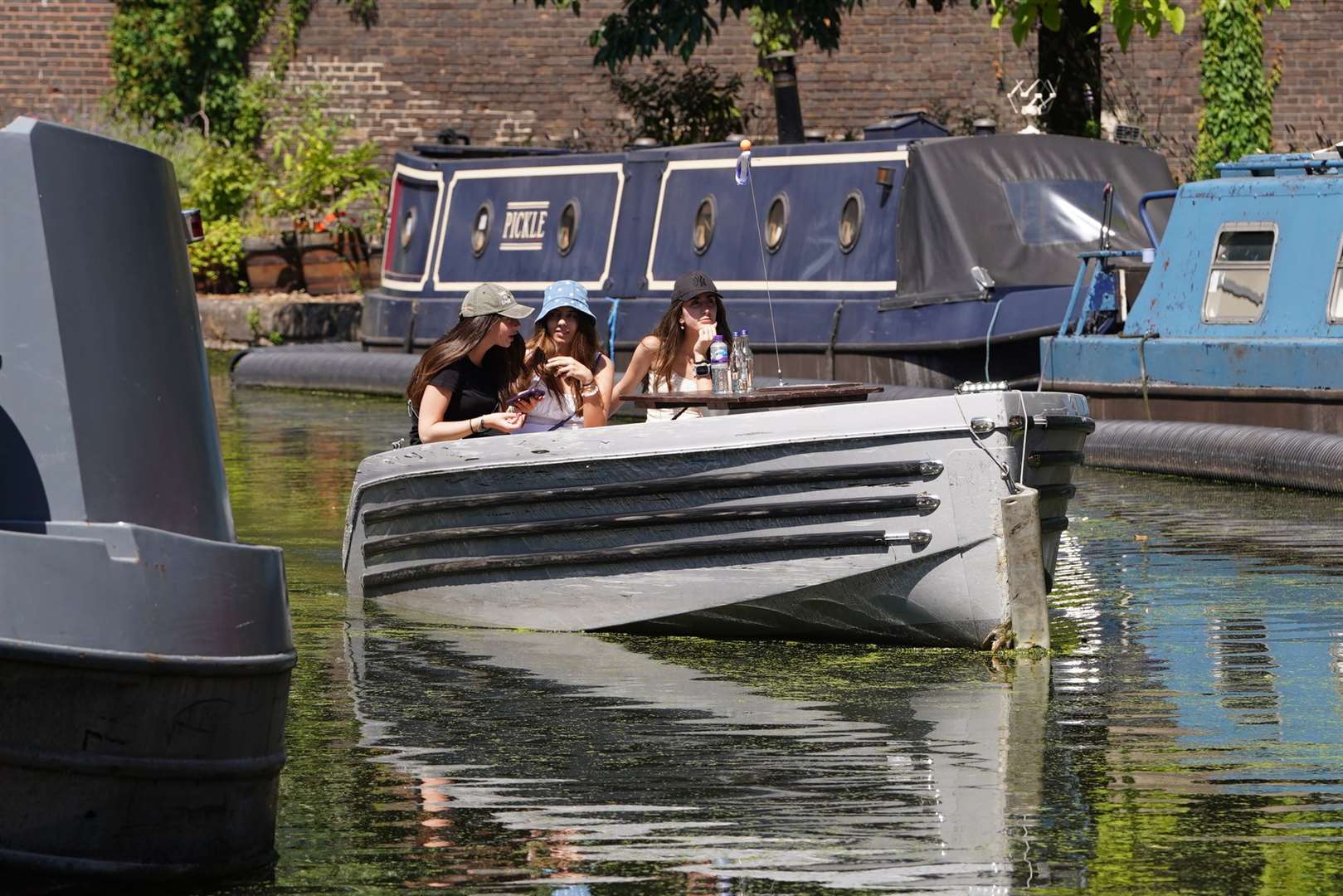 People enjoy a boat ride on the canal in Paddington Basin, London (Lucy North/PA)