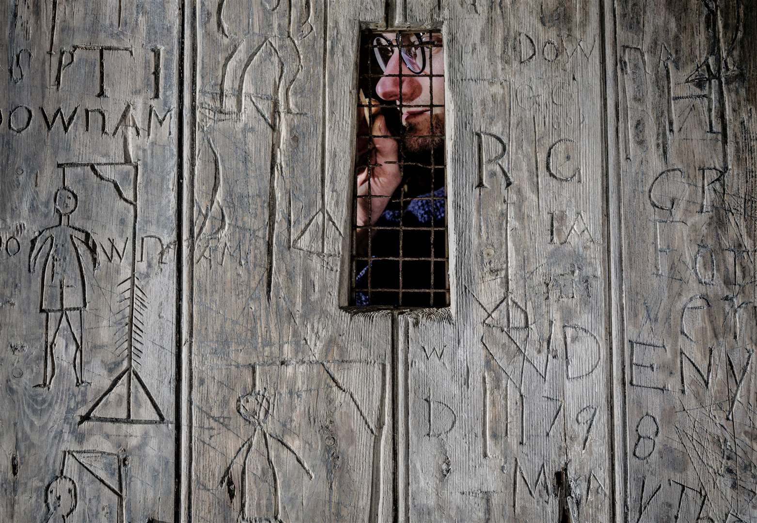 A sailing ship, the date of the French revolution (1789), nine macabre depictions of hangings, and countless initials are scratched into the door at Dover Castle. Picture: English Heritage