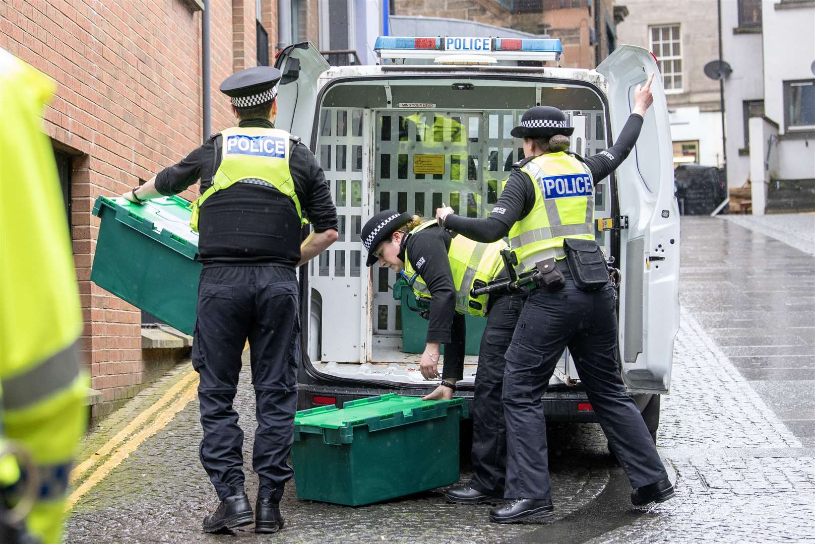 Officers from Police Scotland leave the headquarters of the Scottish National Party in Edinburgh carrying boxes (Lesley Martin/PA)