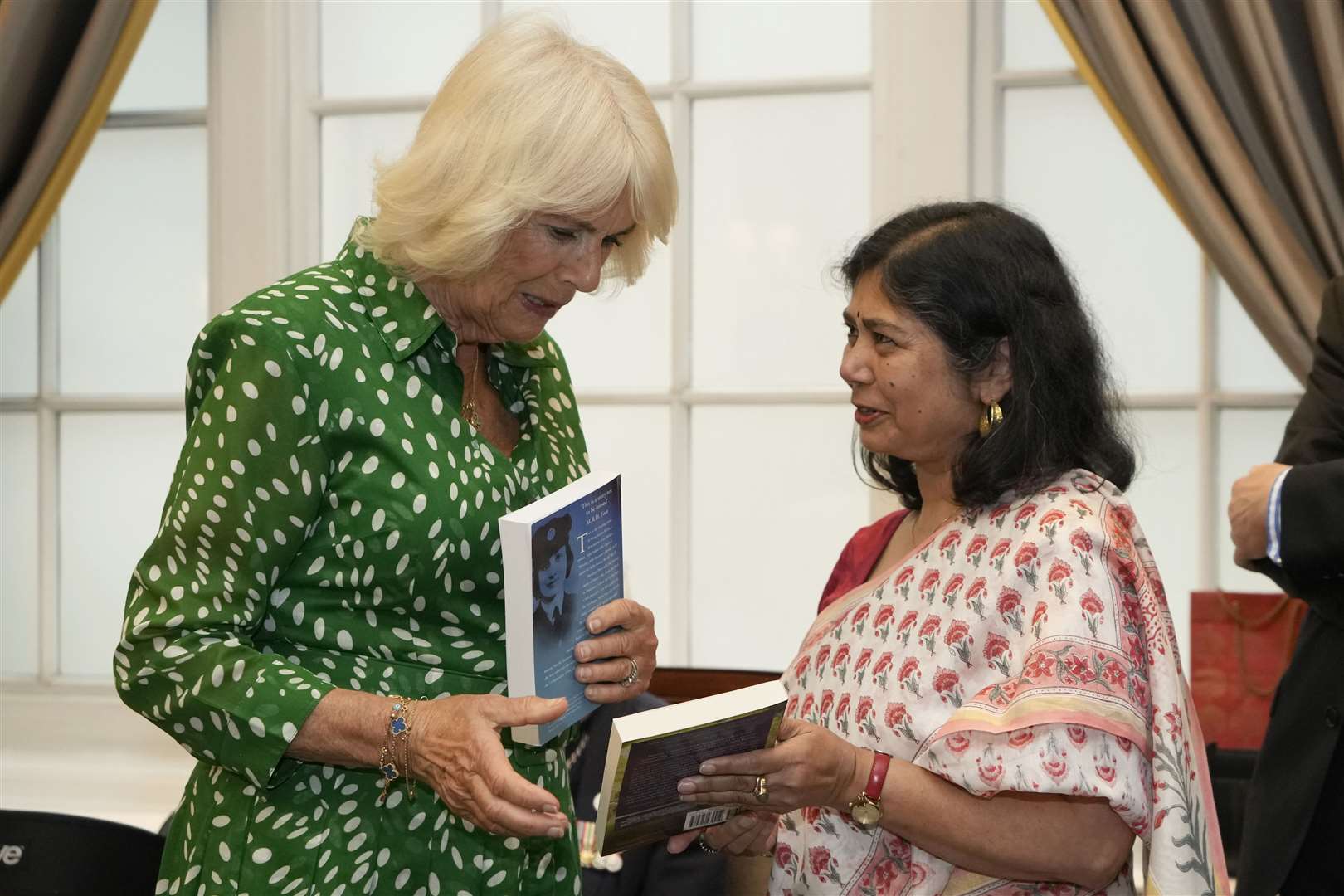 The Queen is presented with a book called The Spy Princess – the Life of Noor Inyat Khan, by author Shrabani Basu (right)(Kirsty Wigglesworth/PA)