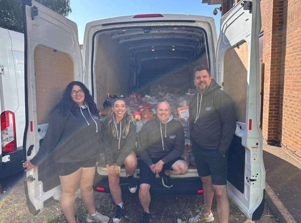 Radio presenters, from left to right: Numi Gildert, Chelsea Little, Andy Walker, Rob Wills with one van full of donations from kmfm’s Tonnes of Tins campaign 2024