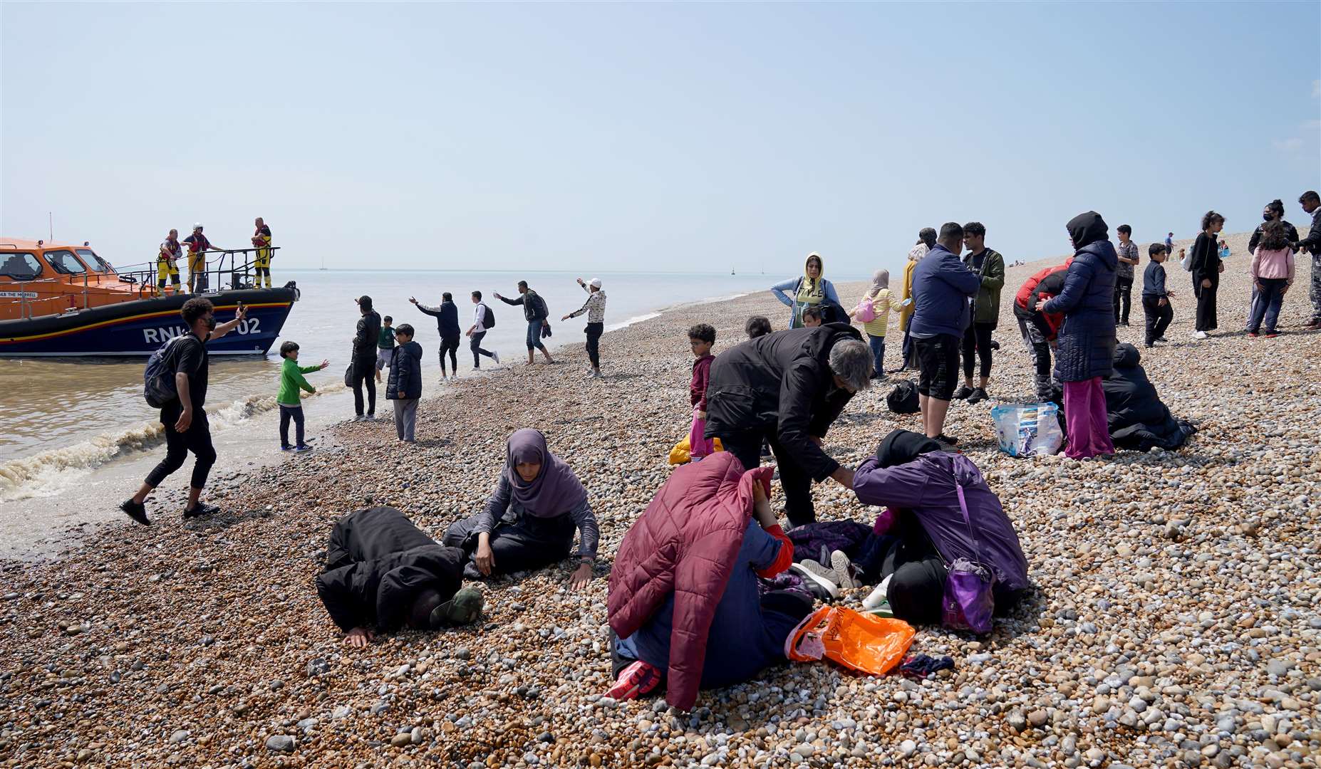 People thought to be migrants make their way up the beach (Gareth Fuller/PA)