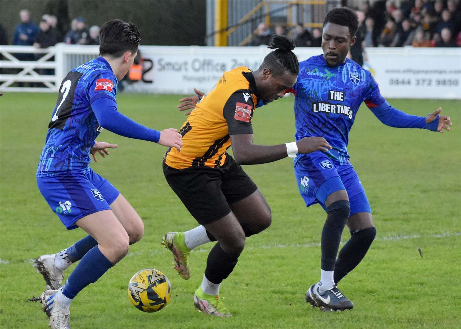 Folkestone's Ira Jackson is closed down by Margate defender Harrison Hatfull, left, and another away player in their 4-0 loss at Cheriton Road. Picture: Randolph File