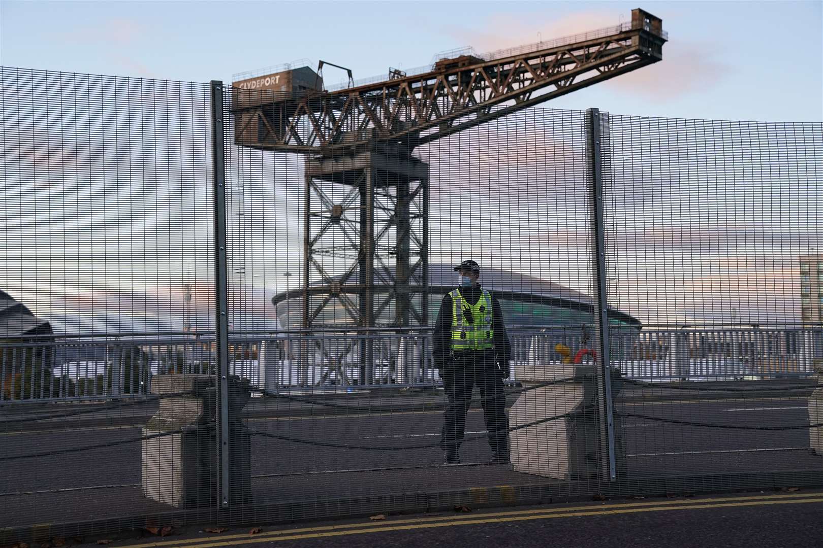 A police officer by the perimeter security fence of the the Scottish Event Campus (SEC) in Glasgow where the Cop26 summit is being held (Andrew Milligan/PA)