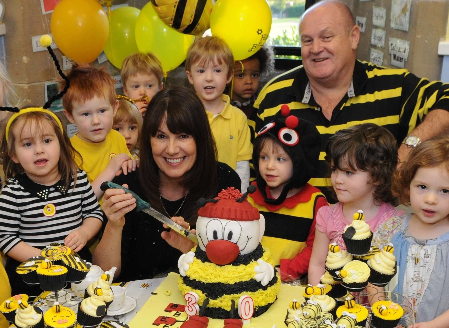 Busy Bees pupils enjoying birthday cakes with founders Marg Randles, managing director and John Woodward, chief executive officer. Picture: Katie Whirledge