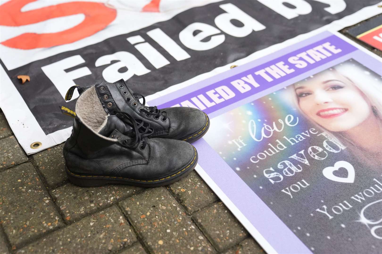 The boots of Tillie King, 21, laid next to her picture by her mother Lisa Bates, 57, who found her daughter dead in her bedroom in Brentwood, Essex in 2020 (Joe Giddens/PA)