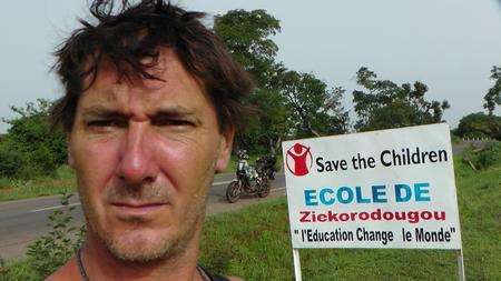 Biker Spencer Conway, who circumnavigating Africa for Save the Children, outside a school run by the charity in Burkina Faso on June 30.