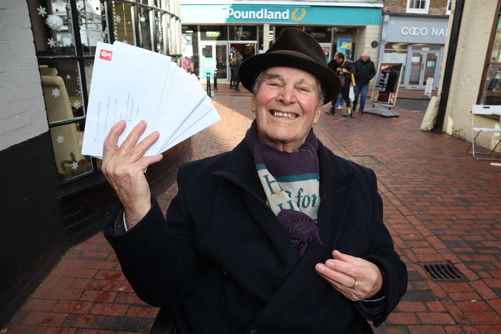 Sittingbourne's 'whistling postman' Dale Howting, pictured with some of cheques he will be posting, has collected £12,800 for charity this year