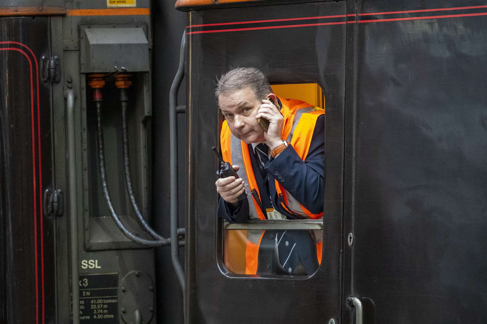 A member of staff looks out of the window of the royal train (Andy Barr/PA)