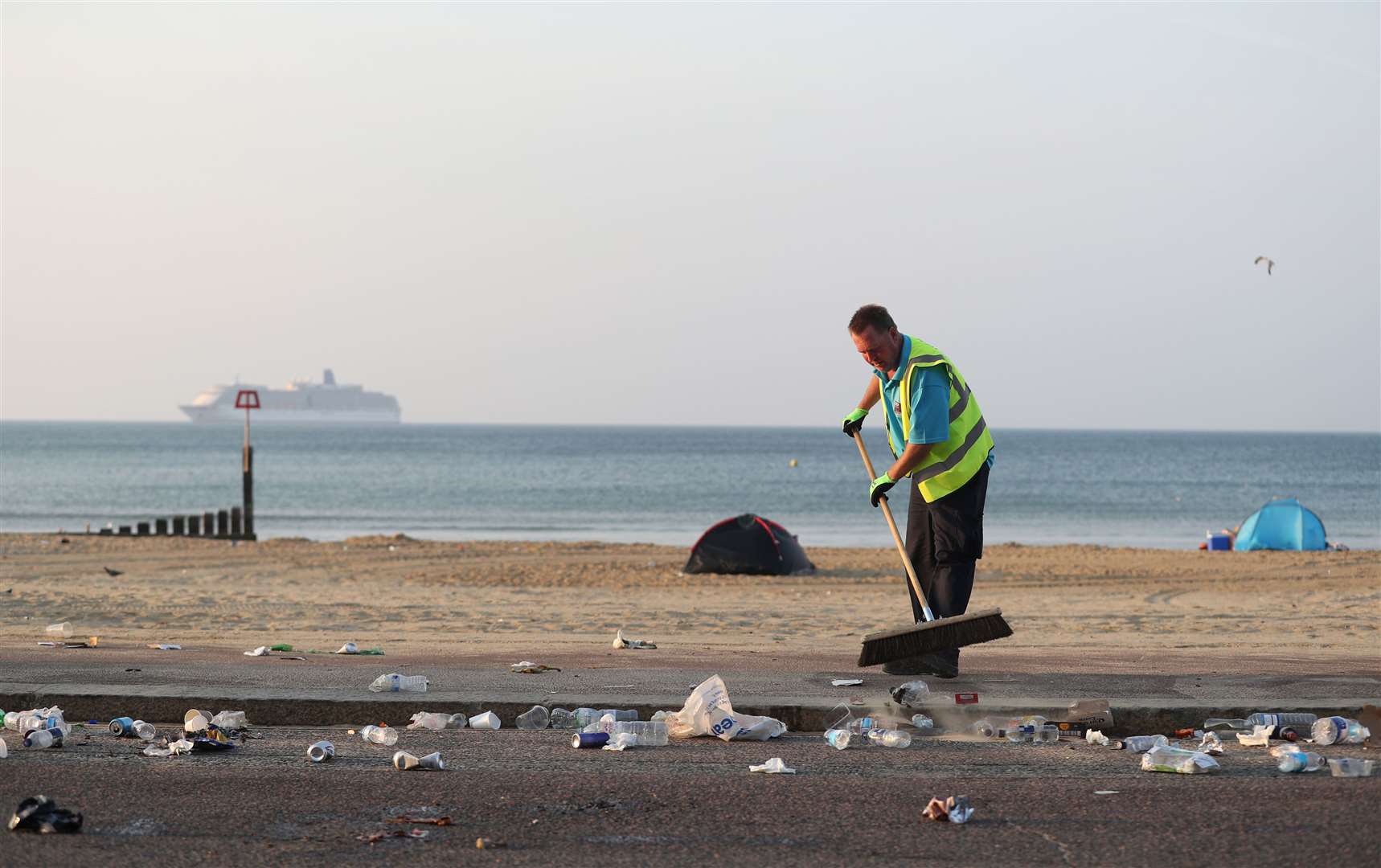 The clean-up gets under way after a busy Saturday on the beach (Andrew Matthews/PA)