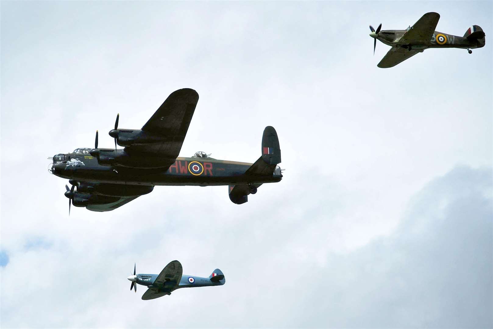 The Hawker Hurricane, top right, alongside the Avro Lancaster, centre, and Supermarine Spitfire, which form the RAF Battle of Britain Memorial Flight (Ben Birchall/PA)