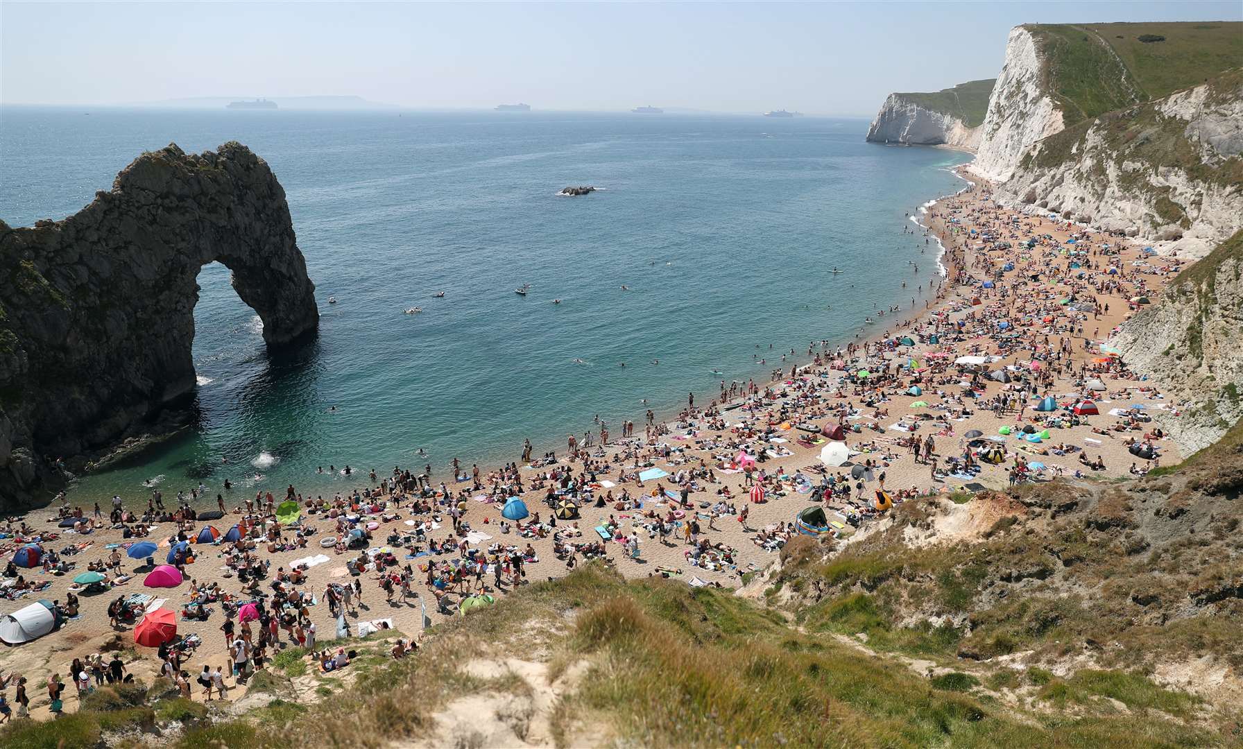 People enjoying the good weather on the beach at Durdle Door, near Lulworth in Dorset, at the end of May as lockdown was relaxed (Andrew Matthews/PA)