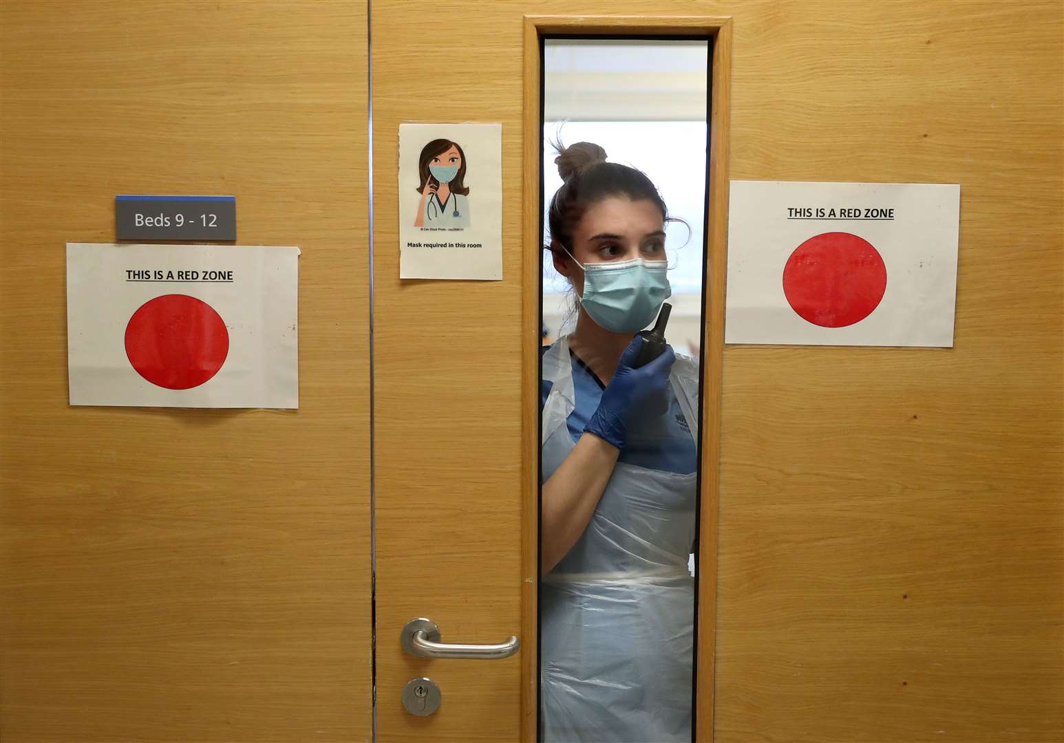 Staff nurse Aria Blyth communicates using a walkie talkie from a Covid area to the ward (Andrew Milligan/PA)