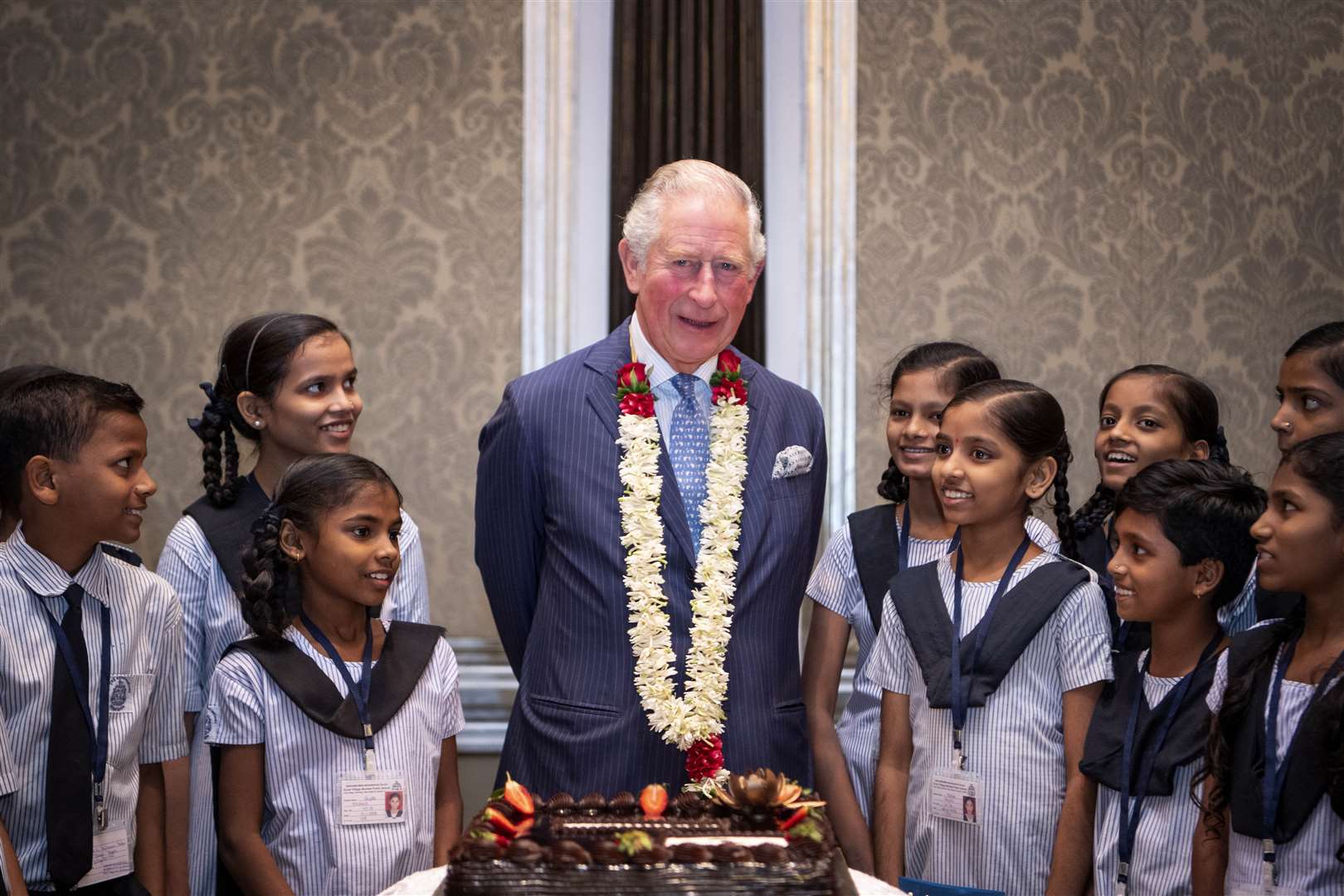 The Prince of Wales receives a birthday cake from school children during a British Asian Trust reception in Mumbai (Victoria Jones/PA)