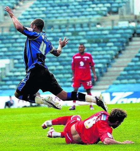 Curtis Weston is feleld by Clark Keltie during Gillingham's 1-0 loss to Lincoln