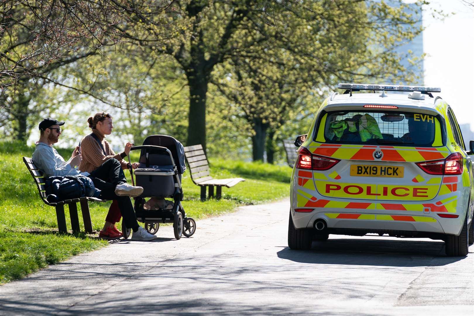 Police stop to move on a couple with a push chair on Primrose Hill, London, during stricter social distancing measures (Aaron Chown/PA)