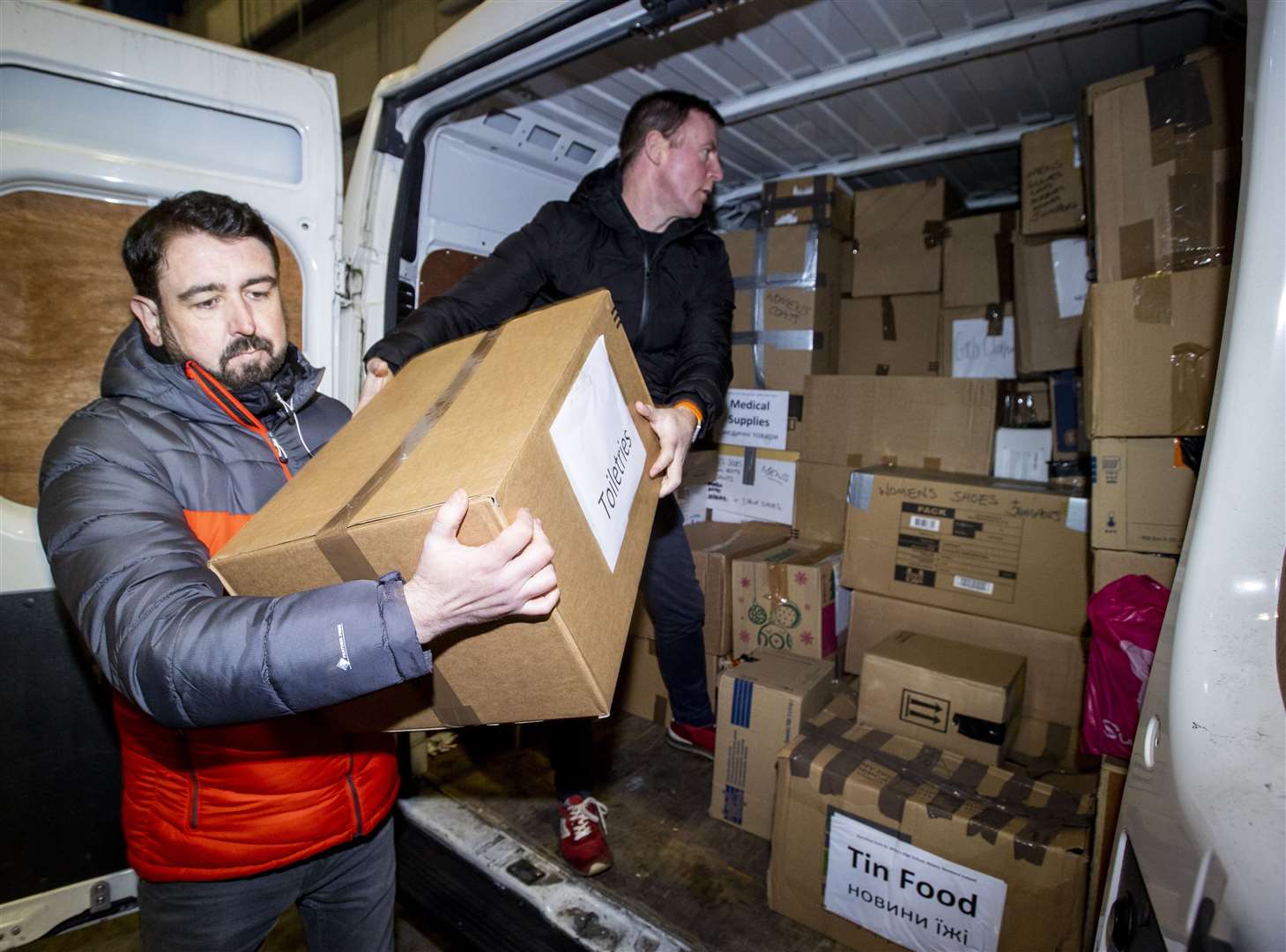 Paul Doherty (left), founder of Woodstock in west Belfast and SDLP MLA Justin McNulty offloading donations (Liam McBurney/PA)