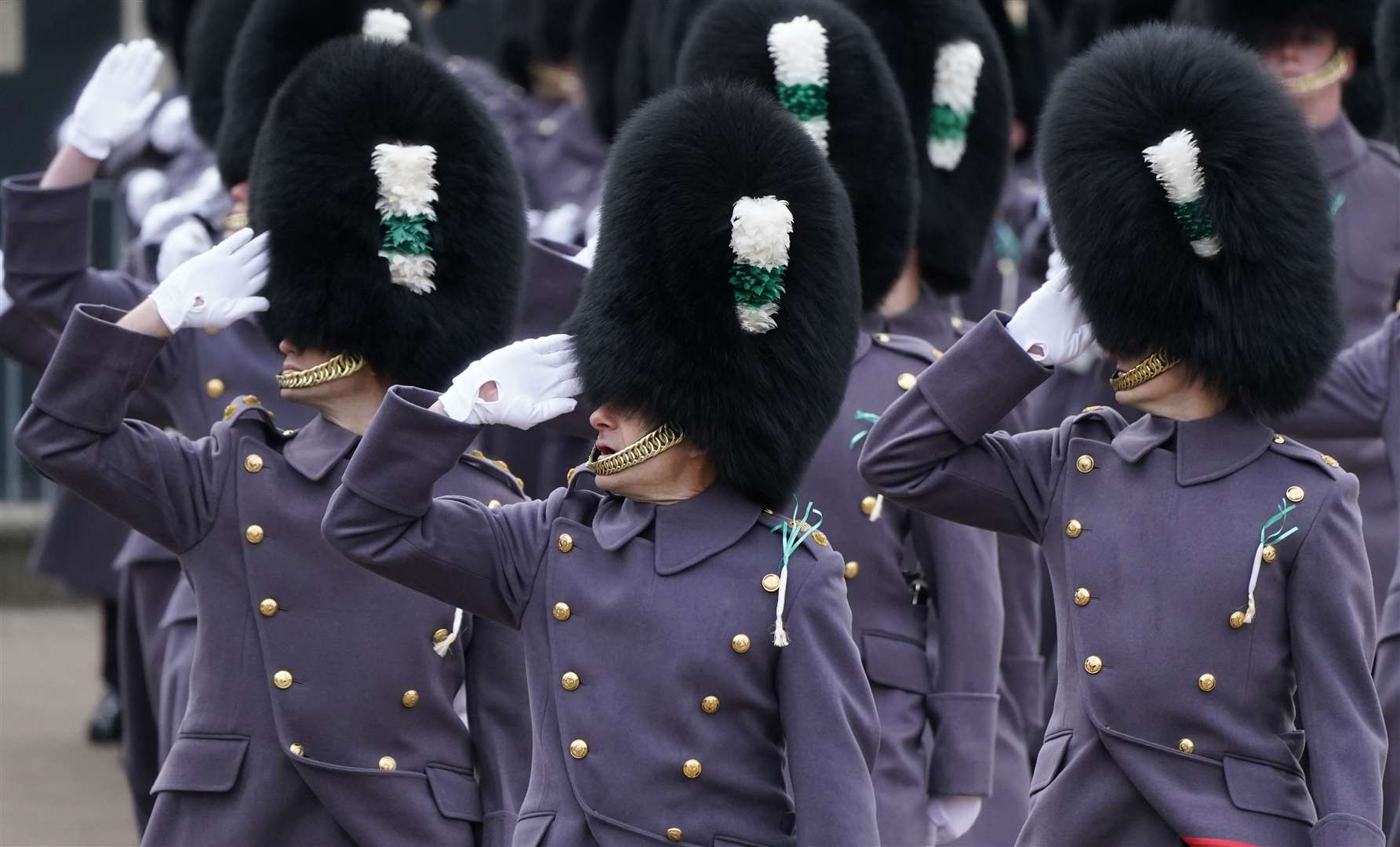 Members of the Welsh Guards salute as they march past the royal couple (Andrew Matthews/PA)