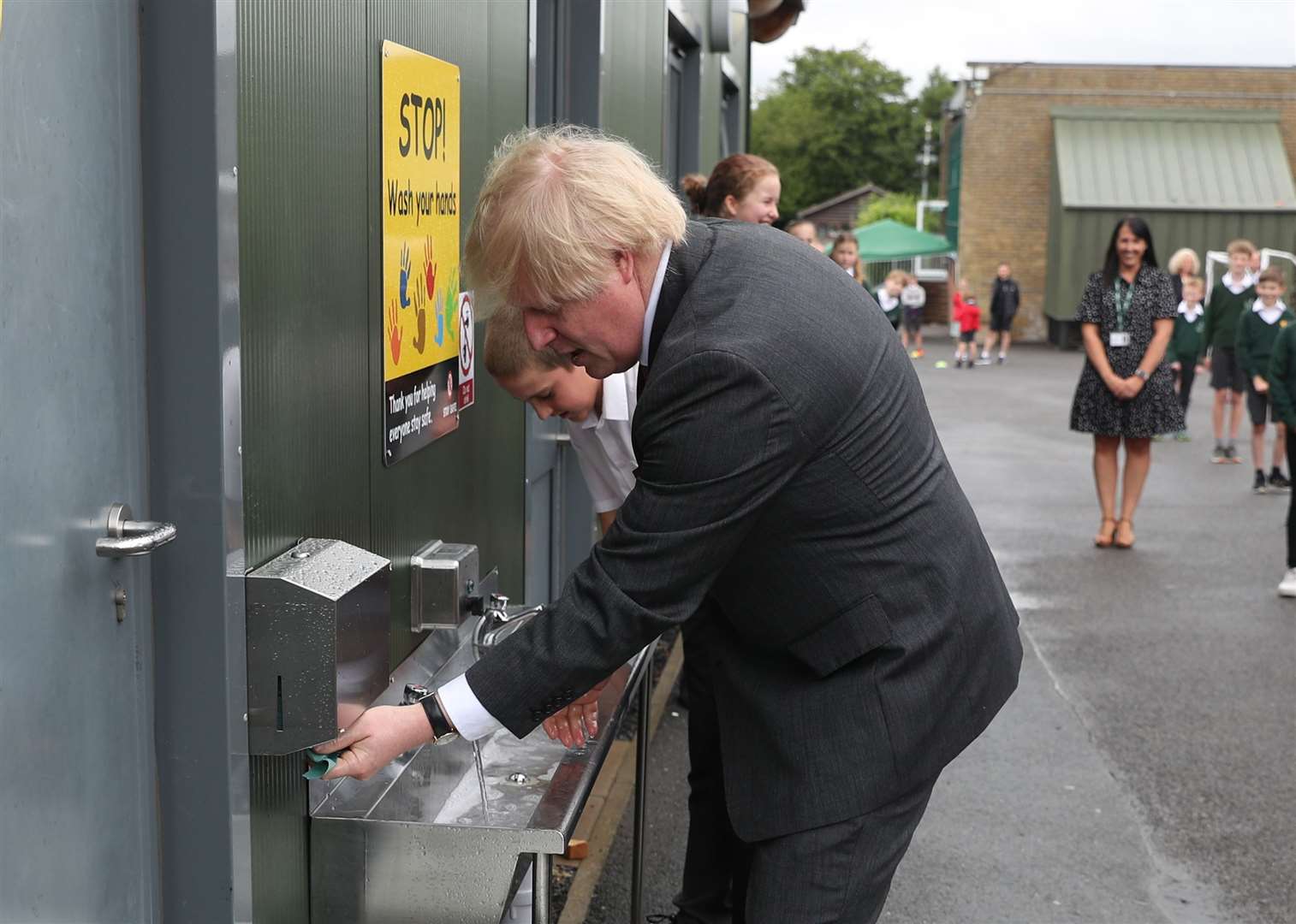 Boris Johnson uses a sink in the playground to wash his hands during a visit to Bovingdon Primary School in Hemel Hempstead (Steve Parsons/PA)