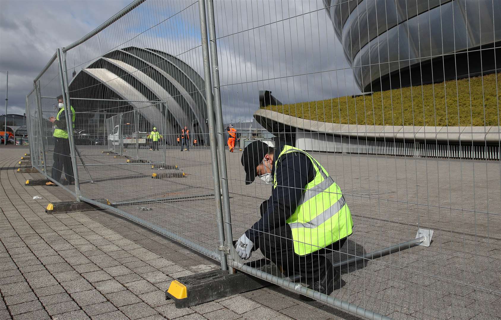 Workers putting up perimeter fencing at the SEC (Andrew MIlligan/PA)