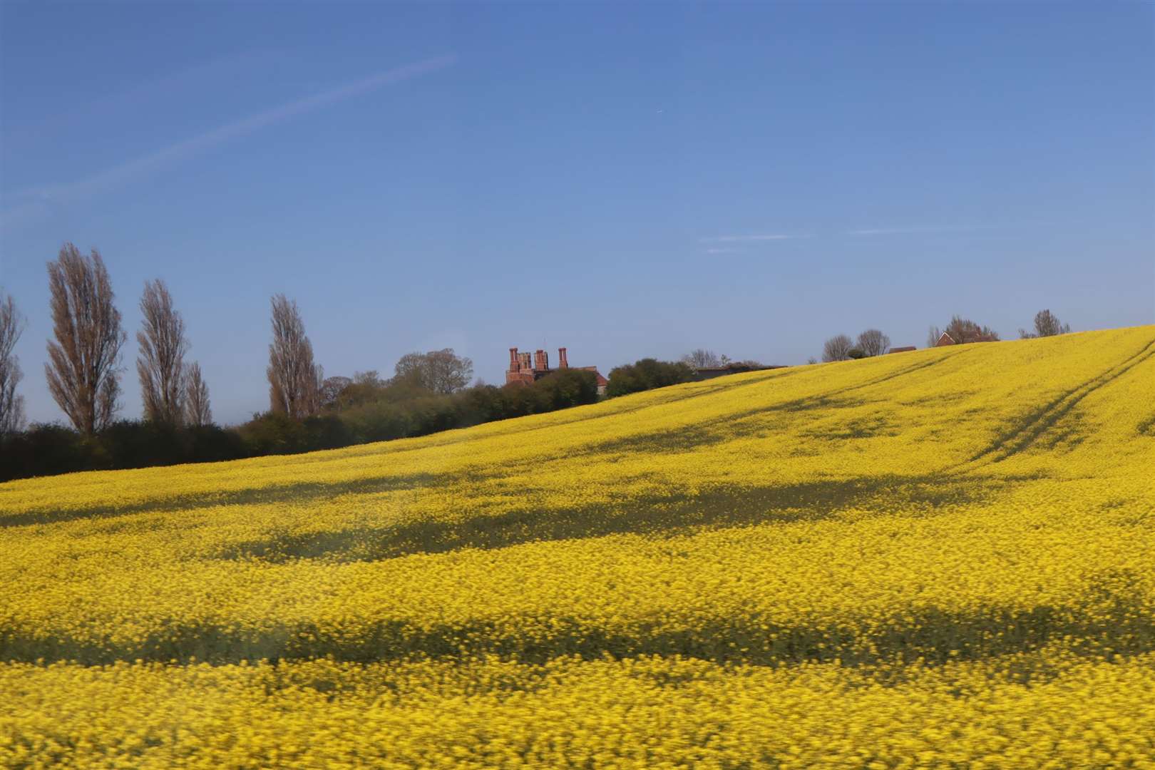 A window with a view from the top deck of a 360 bus approaching Eastchurch