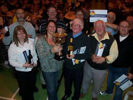 Caroline Codner, Threshers franchise operations manager for the south east of England, presents Mike Power and the Bonny Cravat team with their KM Big Quiz trophy after the team won the south Kent KM Big Quiz. The event raised funds for four causes including the children's walk to school charity Walking Bus.