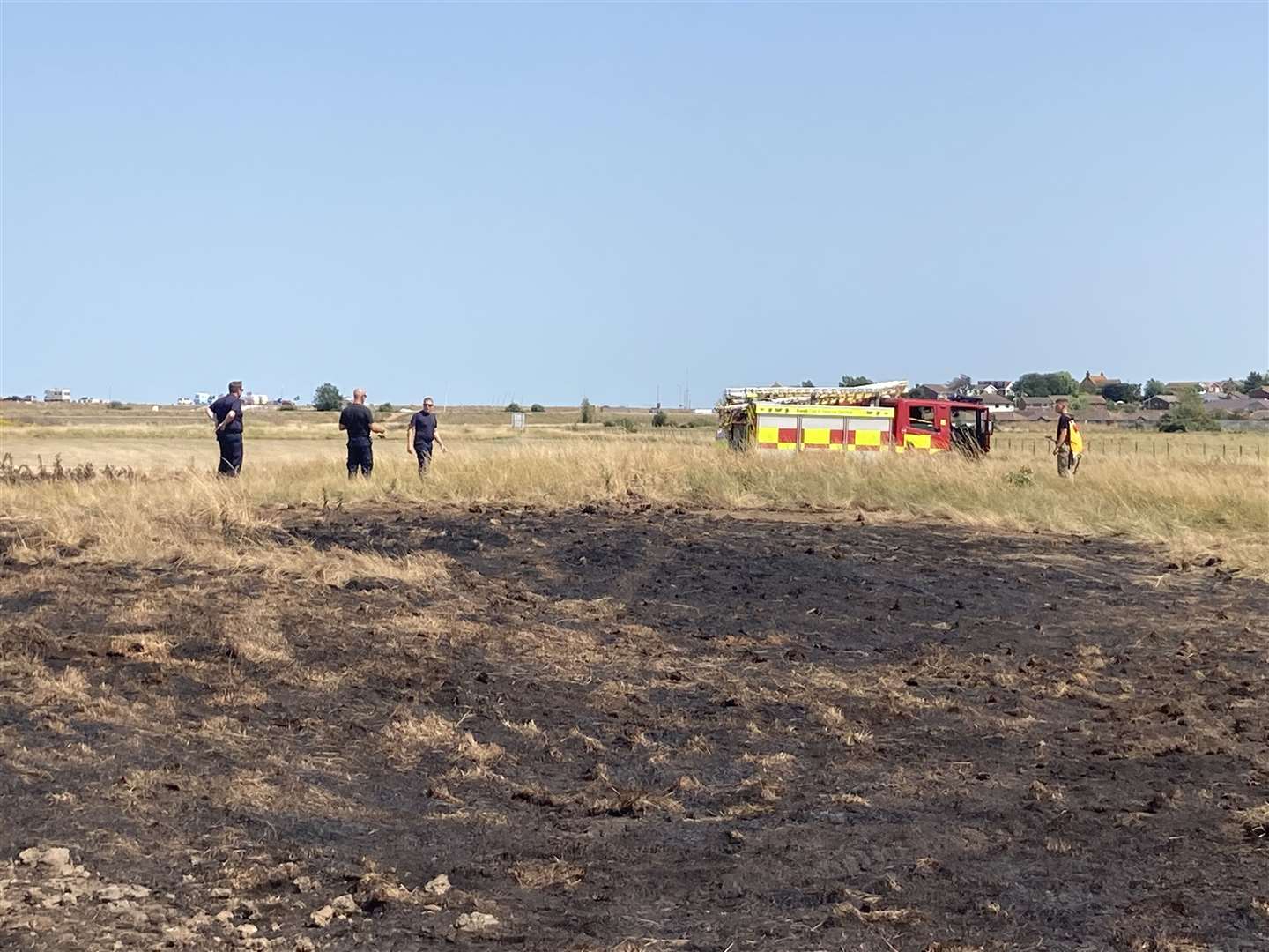 Firefighters return to damp down smoking areas of charred ground at Barton's Point, Sheerness. Picture: John Nurden