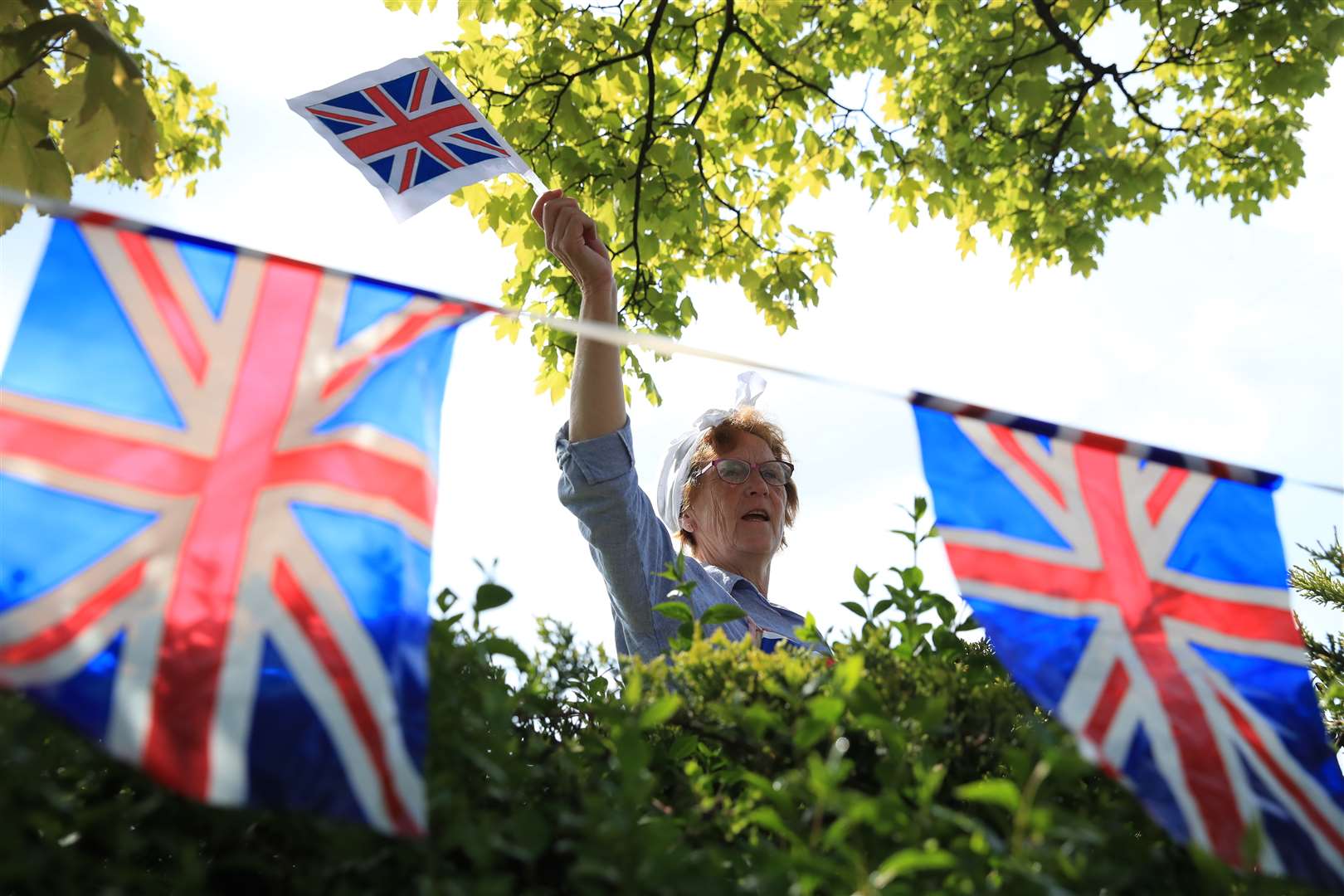 Sheila Daphne, 68, waves to a friend as she joins in her street’s celebrations in Duncan Avenue, Redcar, to mark the 75th anniversary of VE Day (Owen Humphreys/PA)