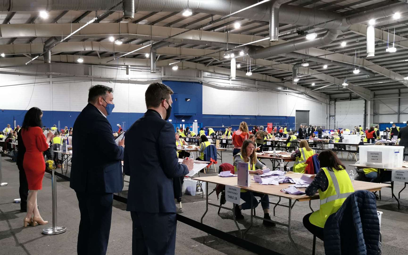 Candidates for the Edinburgh Southern constituency Catriona MacDonald, left, Miles Briggs, centre, and Daniel Johnson watch postal votes being counted (Tom Eden/PA)