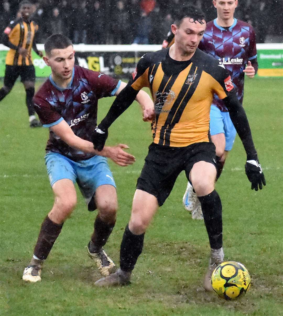 A Hastings player holds to Folkestone top scorer Dan Smith's shirt. Picture: Randolph File