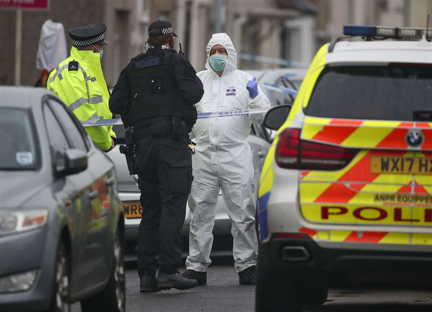 An armed police officer talks to a forensic officer at Summers Street in Swindon (Steve Parsons/PA)