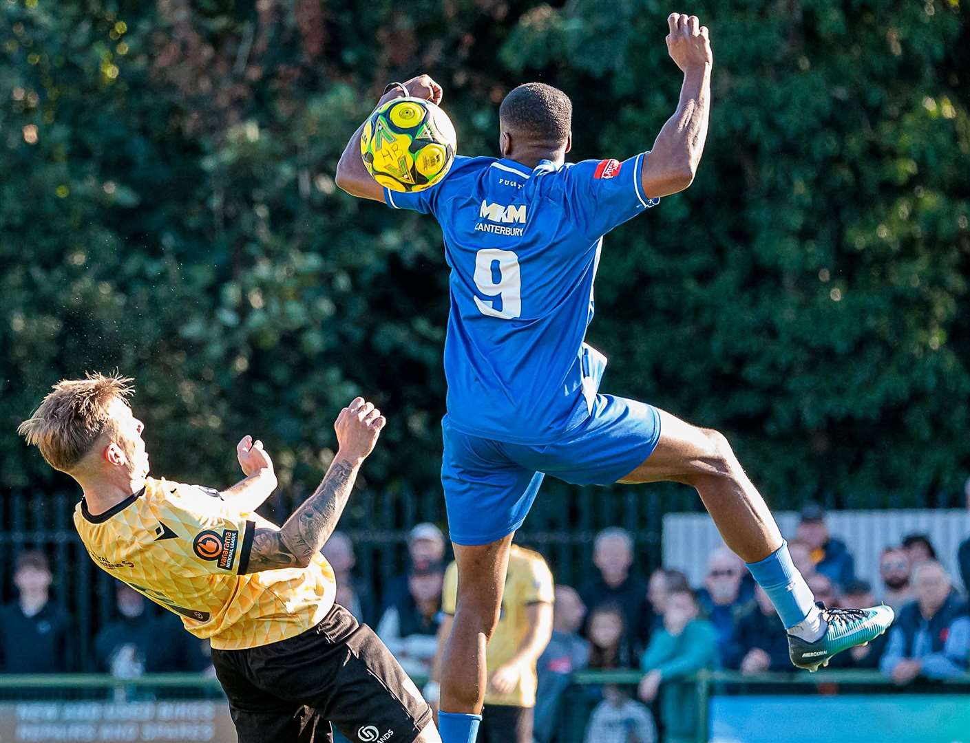 Maidstone skipper Sam Corne and Herne Bay striker Mike Salako are involved in an aerial battle. Picture: Helen Cooper