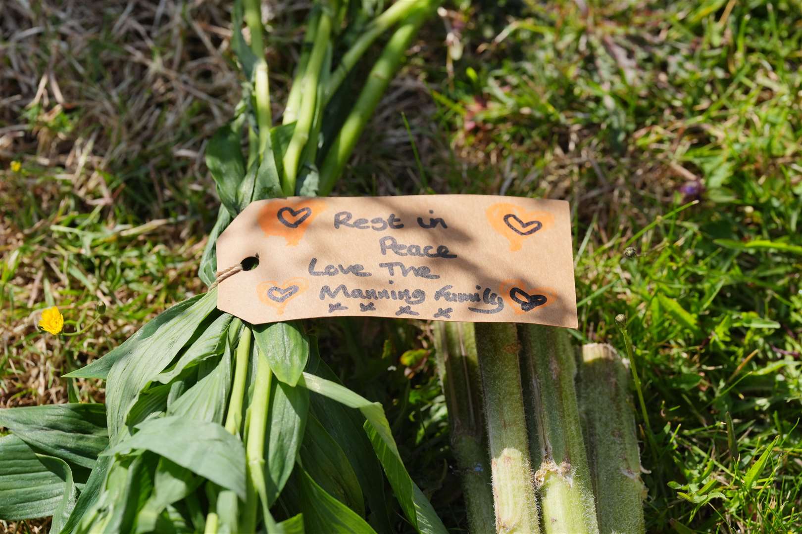 A message attached to a floral tribute left near the scene in Ashlyn Close (Jonathan Brady/PA)