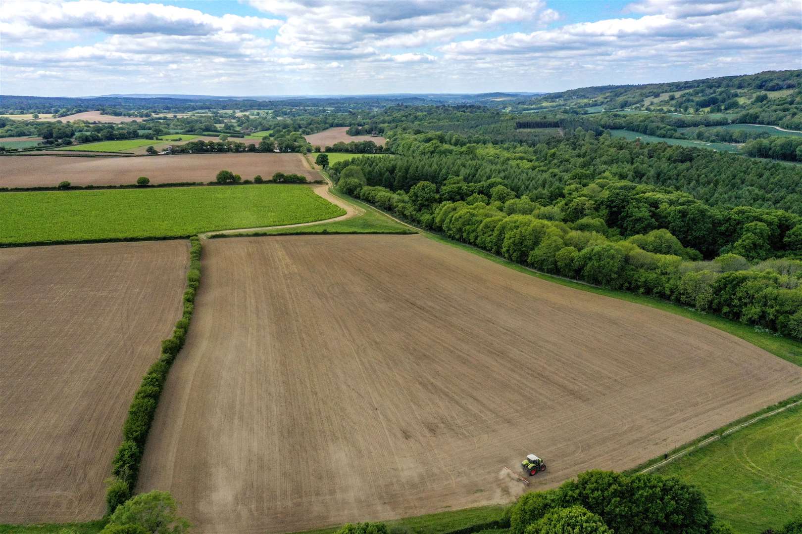 A farmer works in a field at Wotton, near Dorking in Surrey in May (Steve Parsons/PA)