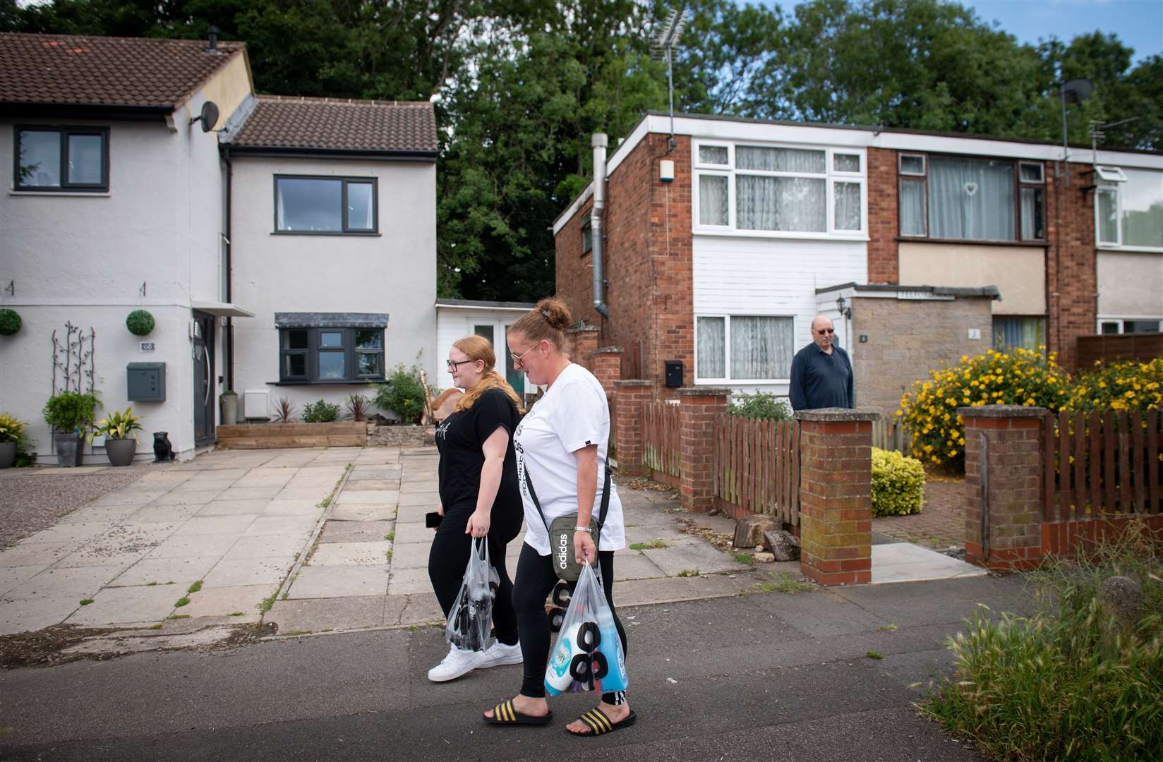 Amy Stephens and her children cross the invisible lockdown boundary in Leicester as David Blohm looks on from his house – on the unrestricted side of the line (Joe Giddens/PA)