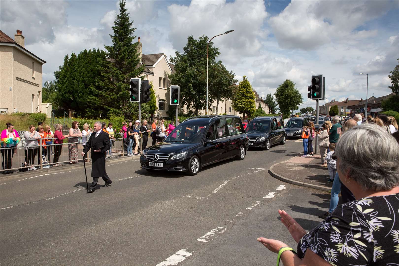 Mourners clapped as the hearses carrying the three children made their way past (Robert Perry/PA)