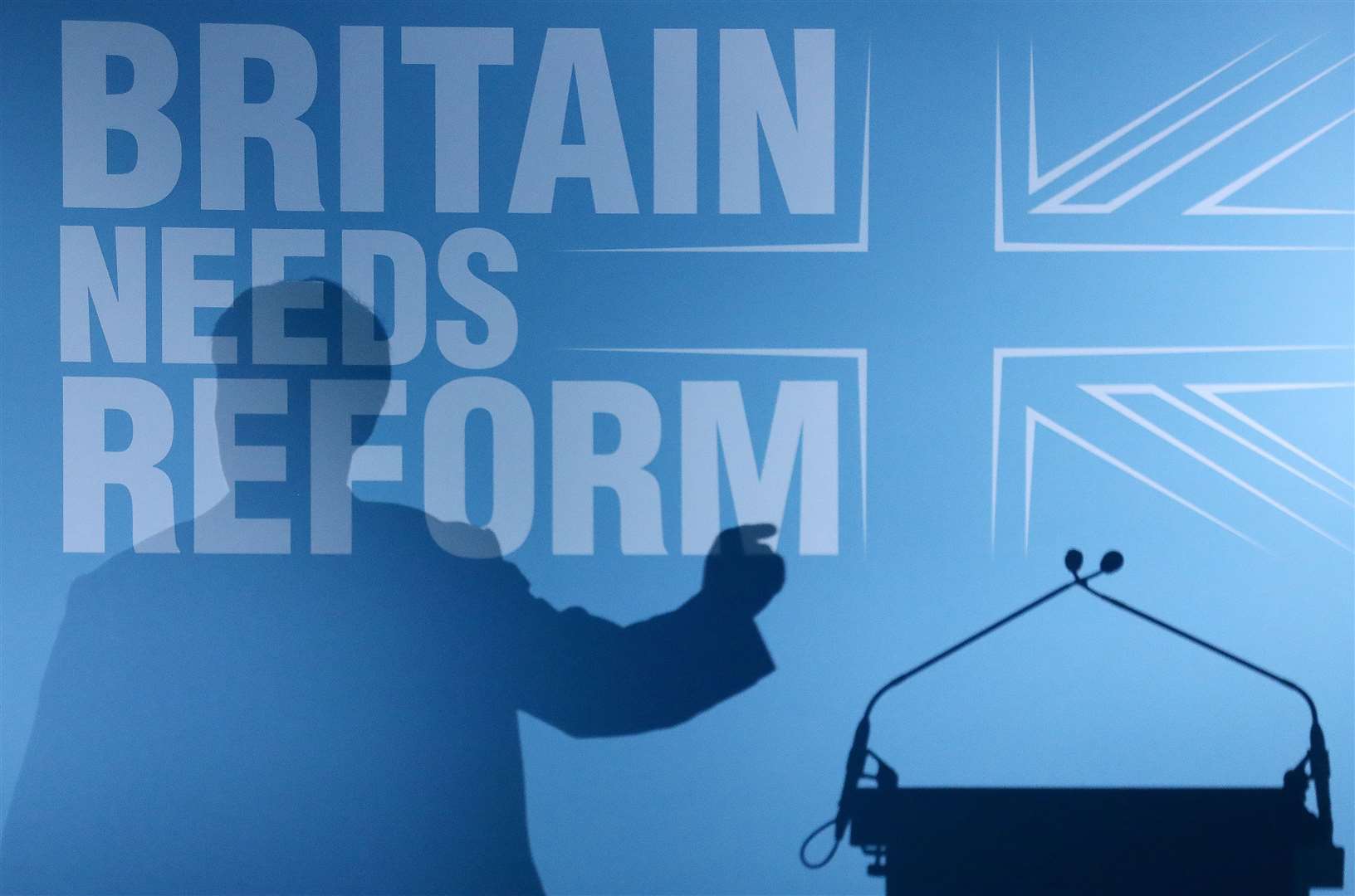 Mr Farage’s shadow falls across the backdrop to a speech in Blackpool on June 20 (Tim Markland/PA)