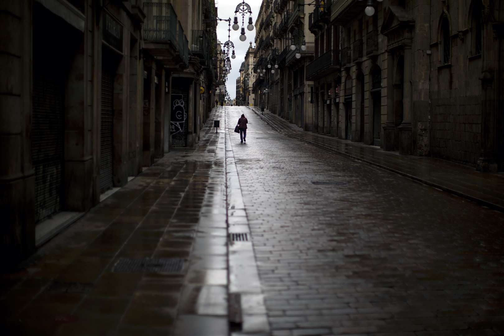 A man walks along an empty street in downtown Barcelona (Emilio Morenatti/AP)