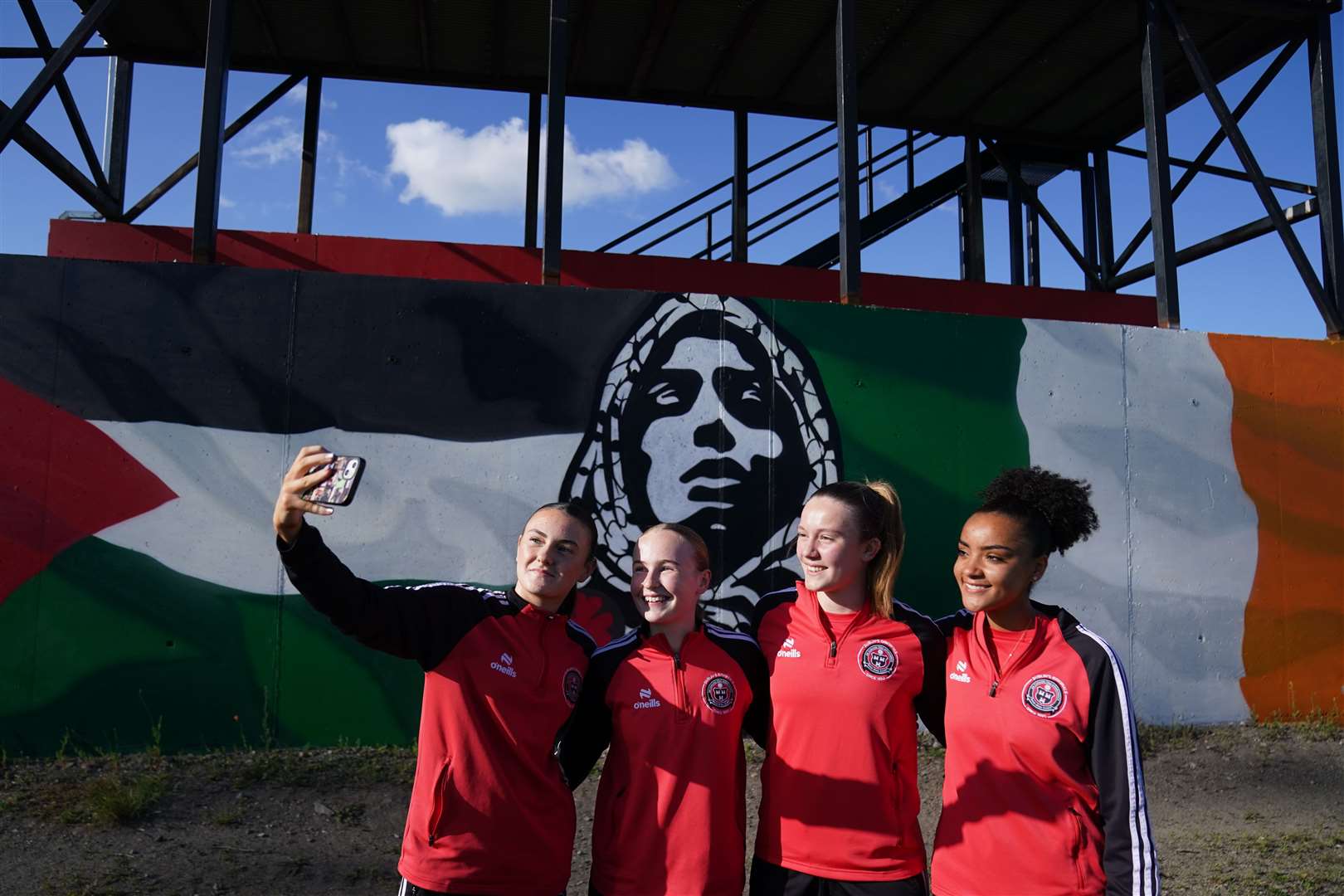 Bohemians Women players pose by a new mural ahead of their friendly match against the Palestine women’s national team (Brian Lawless/PA)