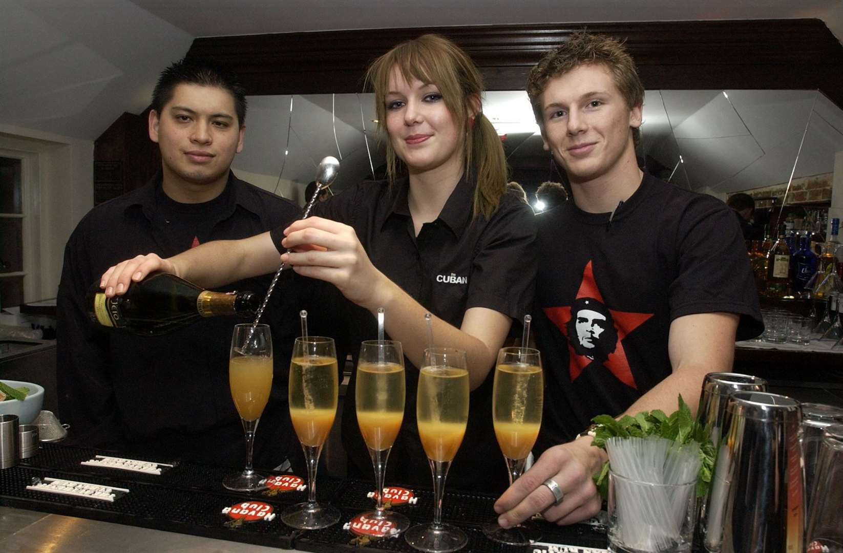 Staff busy behind the bar preparing colourful drinks at The Cuban's opening night party