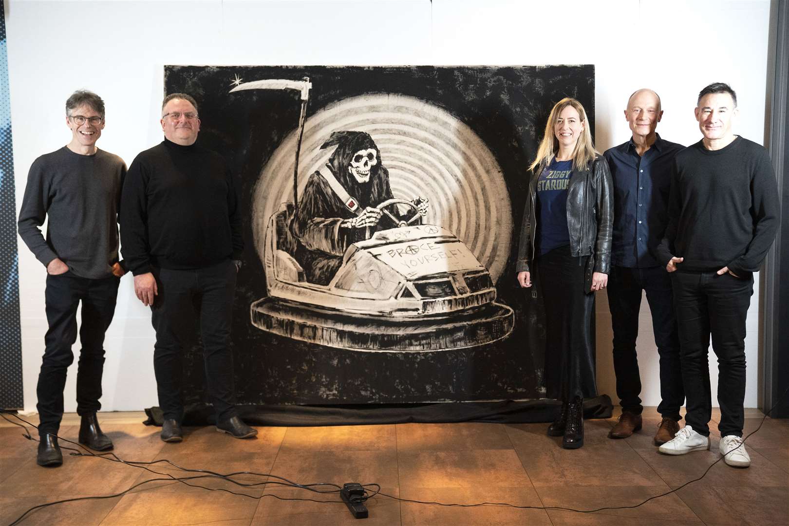 Brace Yourself! band members with Banksy’s original Grim Reaper painting Brace Yourself! (Kirsty O’Connor/PA)