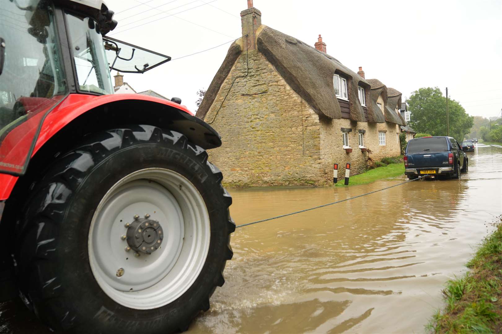 A tractor was used to rescue a vehicle stuck in flood water in Grendon, Northamptonshire (Joe Giddens/PA)