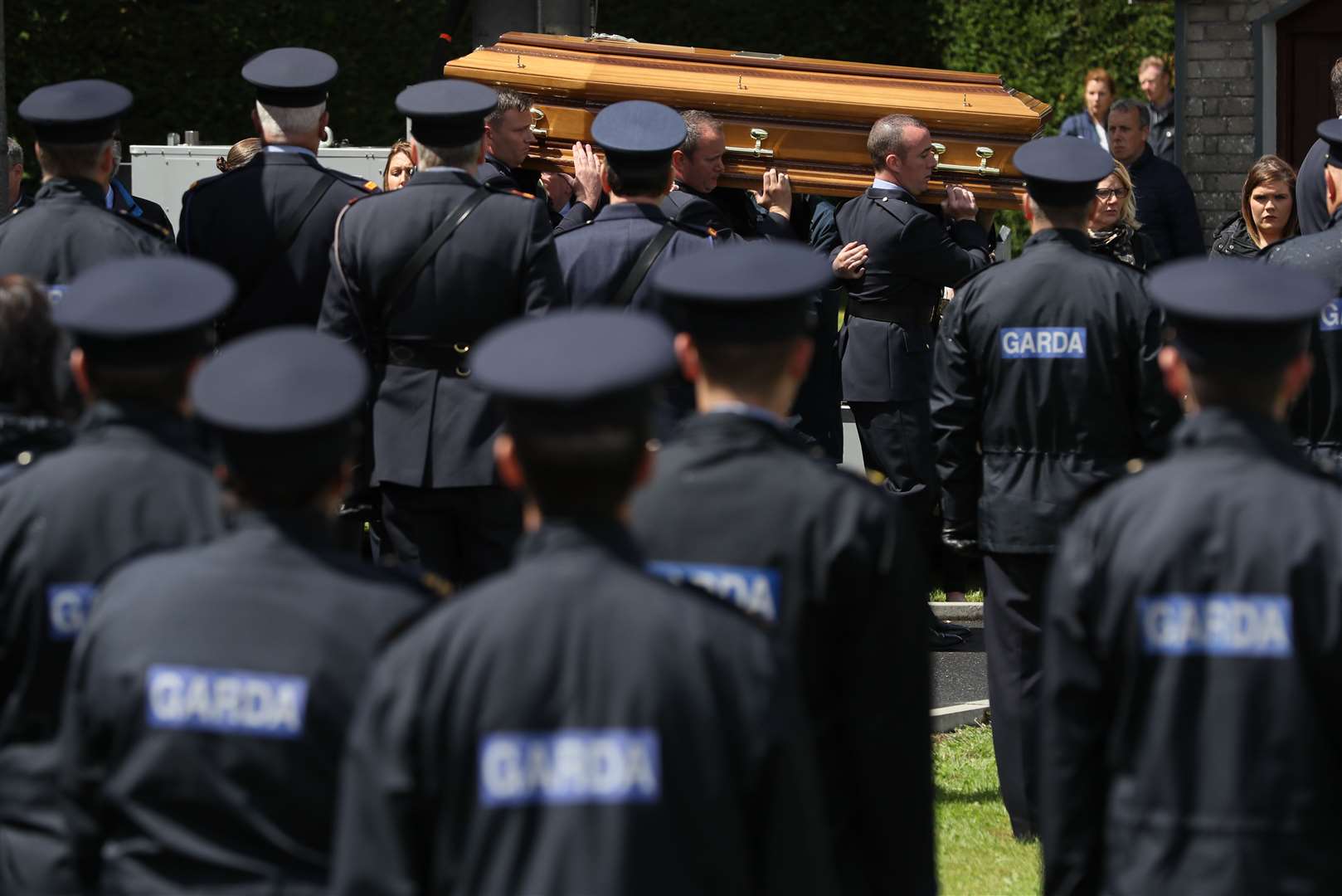 Gardai watch on as the coffin is carried from St James’s church to the cemetery in Charlestown (Brian Lawless/PA)