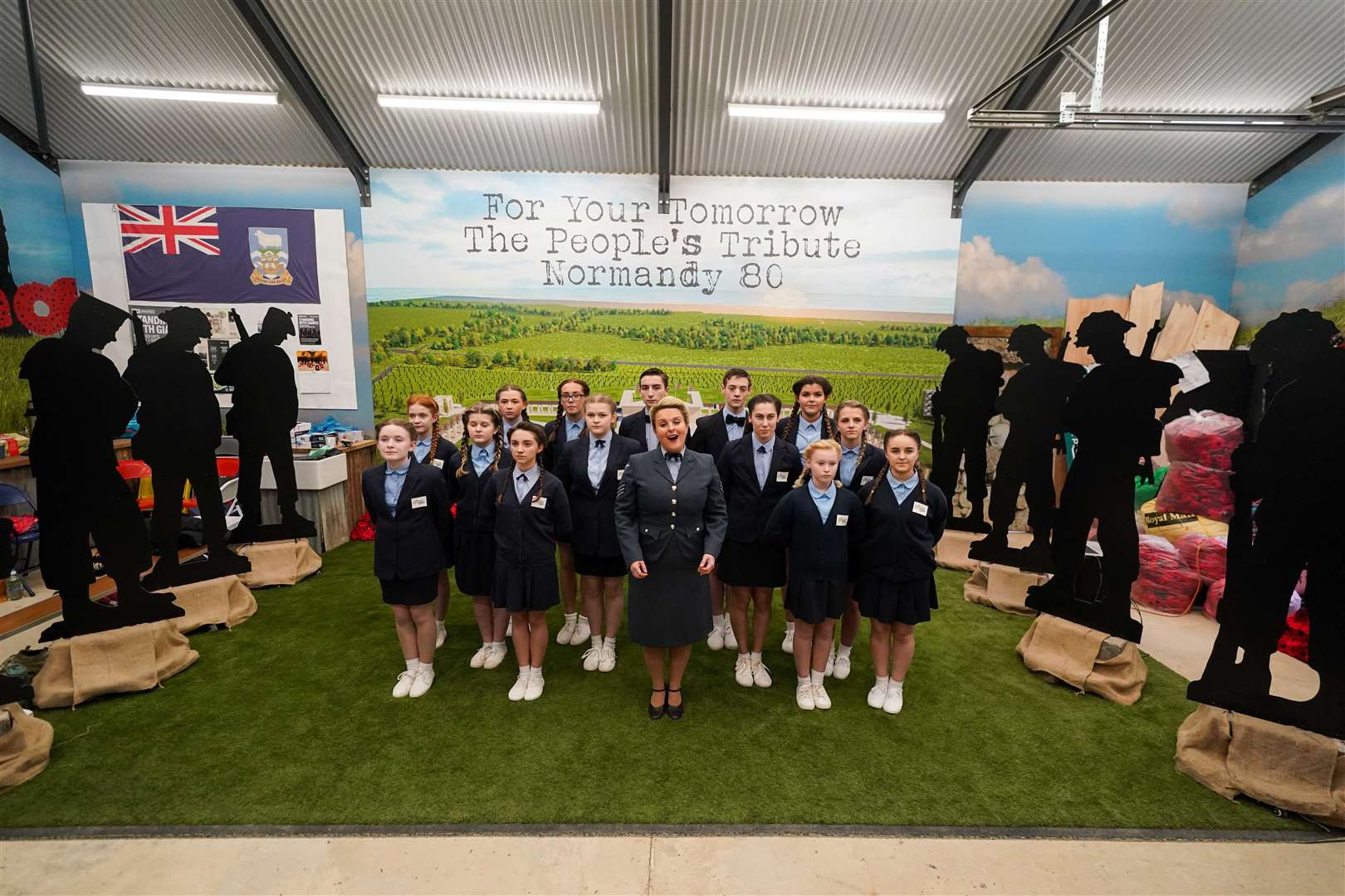 The D-Day Juniors sing at the workshop in Oxford where more than 200 silhouettes of Second World War soldiers are being made for the 80th anniversary of D-Day (Jacob King/PA)