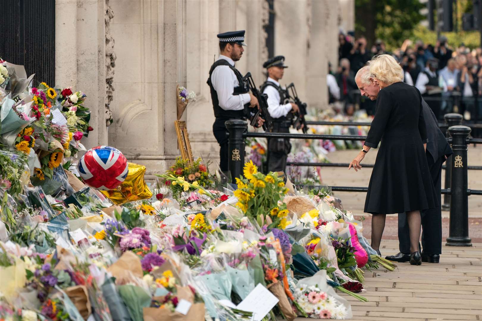 The King and Queen look at flowers outside Buckingham Palace (Dominic Lipinski/PA)