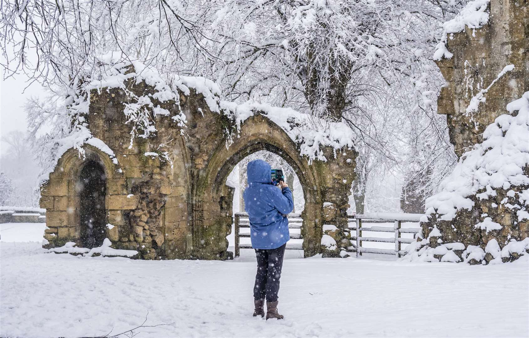 A woman takes a photograph in the grounds of Knaresborough Castle (Danny Lawson/PA)