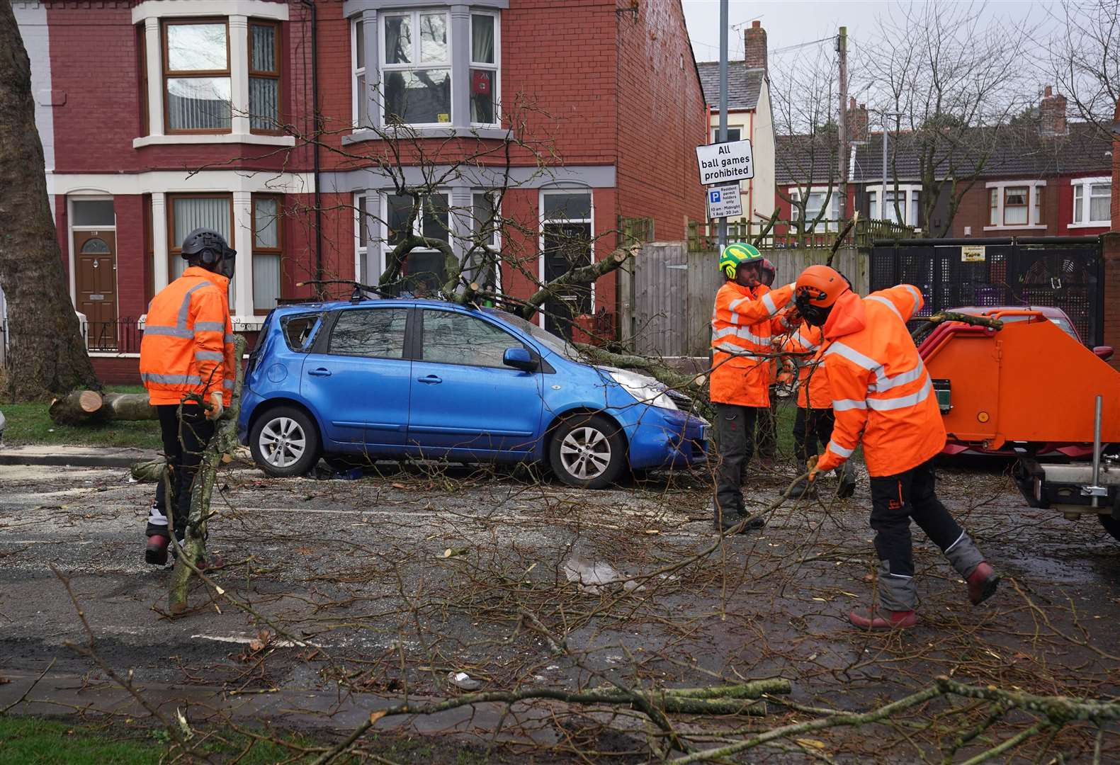 Tree surgeons clear away a fallen tree in Liverpool (Peter Byrne/PA)