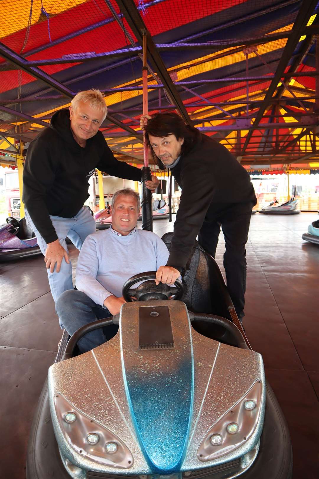 Cllrs Mike Baldock, left, and Richard Palmer give funfair boss Carlos Christian a hand on the dodgems at Smith's funfair at Barton's Point, Sheerness