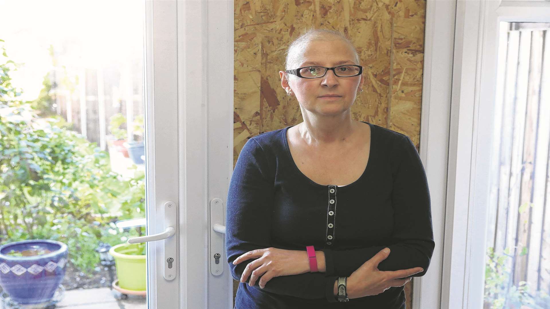 Claire Mcintosh stands next to her broken door where burglars gained access to her house