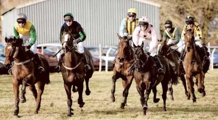 Runners and riders head into the fourth jump in the first race of the day